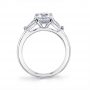Side profile of a white gold three stone diamond engagement ring from the Sylvie Collection featuring a large round diamond in the center with two baguette cut diamonds on the side