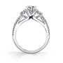 Side profile of a while gold three-stone diamond engagement ring from the Sylvie Collection featuring three diamonds at the top as well as two rows of diamonds going down either side