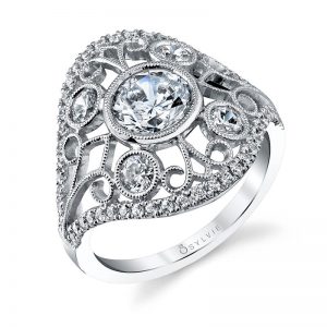 A white gold diamond ring from the Sylvie Collection with a diamond edge and bezel set diamonds among a swirling design