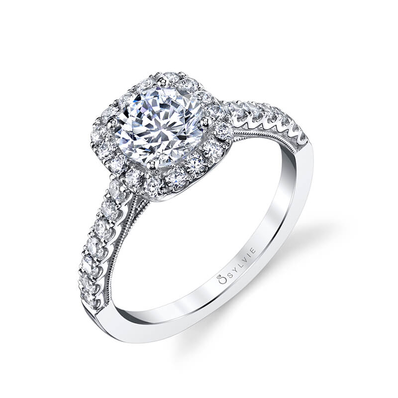A white gold diamond engagement ring from the Sylvie Collection featuring a prominent round diamond in the middle of a cushion shaped halo