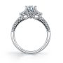 Side profile of a white gold three stone diamond engagement ring with a peek-a-boo diamond on the side from the Sylvie Collection