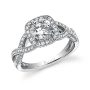 A white gold diamond engagement ring featuring a cushion shaped halo around a round diamond with milgrain accents