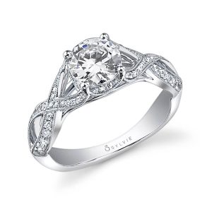 A white gold diamond engagement ring from the Sylvie Collection featuring a round diamond in the center and a twisting split shank with diamonds and milgrain accents