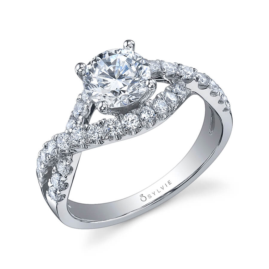 A white gold diamond engagement ring from the Sylvie Collection featuring a twisting diamond shank and prominent round diamond in the center