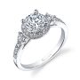 A white gold three-stone diamond ring with a halo around the center stone from the Sylvie Collection